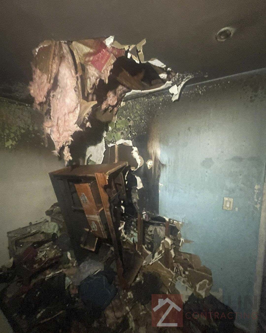 Fire damage inside a room with burned and damaged walls and ceiling after restoration work.